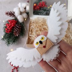 a hand is holding an ornament that has been made to look like an owl