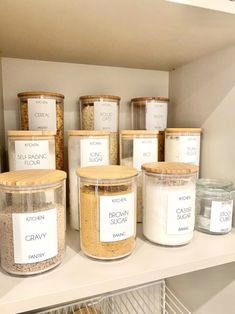 several jars with labels on them are sitting on a shelf in a pantry next to bread