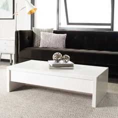 a white coffee table sitting in front of a black couch