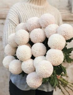 a woman holding a bouquet of white flowers