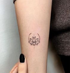 a woman's arm with a lotus tattoo on the left side of her body