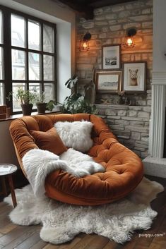 a living room filled with furniture and a fire place next to a brick wall in front of a window