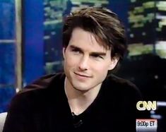 the young man is sitting down in front of a news anchor and looking at the camera