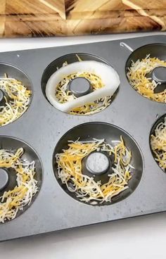 a muffin tin filled with cheese and other toppings on top of a counter