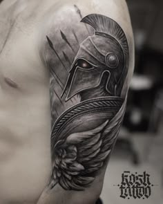 a man's arm with a spartan helmet on it and an arrow in the middle