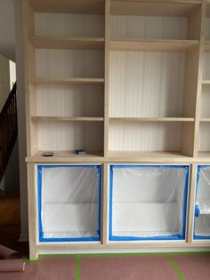 an unfinished bookcase with blue tape on it