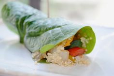 a green leaf filled with food sitting on top of a white plate