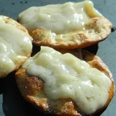 three biscuits covered in cheese sitting on top of a table