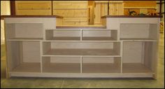 an unfinished entertainment center with shelves and drawers