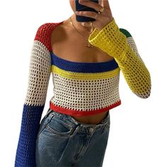 a woman taking a selfie with her cell phone wearing a multicolored sweater