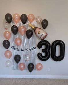 balloons and streamers are arranged in the shape of an 30th birthday sign with a bottle of champagne