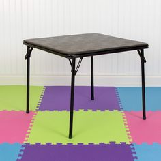 a black table sitting on top of a multicolored floor