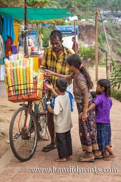 a man is selling carrots to children on the side of the road in india