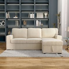 a white couch sitting on top of a wooden floor in front of a book shelf