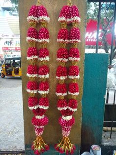 some red and white flowers hanging from a pole