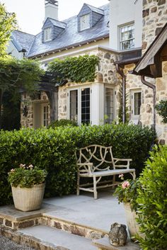 a bench sitting in front of a stone house