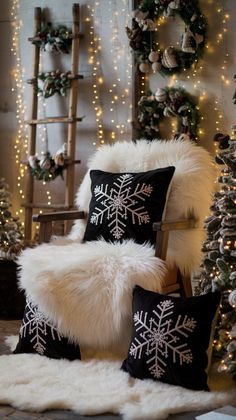 a chair with two pillows on it in front of a christmas tree and garlands