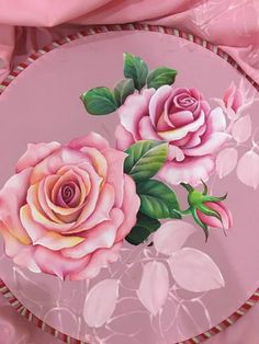 a pink plate with two roses painted on it