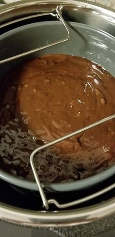 a pot filled with brown liquid sitting on top of a stove