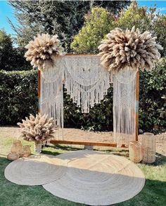 an outdoor wedding ceremony set up with flowers and macrame balls on the grass