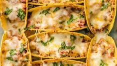 several tacos filled with meat and cheese sitting on top of each other in tortilla shells