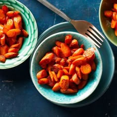 two bowls filled with cooked carrots next to a fork