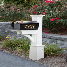 a white mailbox with the number 2090 on it in front of some flowers