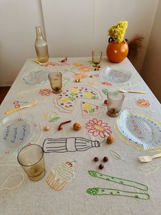 a table topped with lots of different types of dishes and utensils on top of a white table cloth