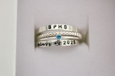 Class Ring, School Name Ring, Class of 2023, Class of 2024, Class of 2025, Class of 2026, Class of 2027, College Ring, High School Ring An alternative to traditional class rings, we're excited to offer a modern stackable version that is fun to wear! Please read all details below. Your set will include 4 rings: 1. School Name Ring   2. Birthstone Ring OR School Color 3. Beaded Spacer Ring 4. Class of  Ring S I Z I N G If unsure of size, please have a jeweler size your finger.  I am unable to resi Class Ring Alternative, Class Ring Ideas, Class Of 2027, Class Of 2026, High School Rings, College Ring, School Rings, College Rings, Class Rings