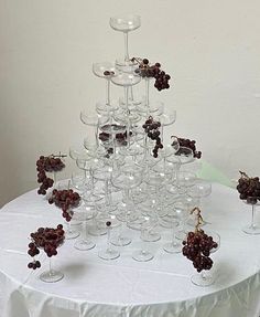 a bunch of wine glasses sitting on top of a white table cloth covered tablecloth