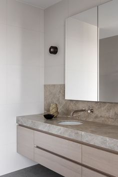 a bathroom sink with a mirror above it next to a wall mounted faucet