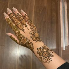 a woman's hand with henna tattoos on it