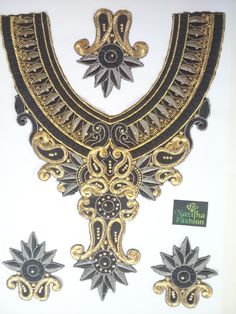 an ornate gold and black necklace with two matching earrings on the front, and one in the back