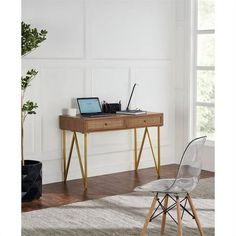 a desk with a laptop on it and a chair next to it in front of a window