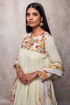 Off white kalidar kurta with floral embroidered yoke and sequin detailing. Paired with dhoti and scallop hem dupatta.
Component: 3
Printed, Embroidered
Neckline: Round
Sleeve Length: Three Quarter
Fabric: Mulmul, Kota Doria
Color: White
Drawstring with tassels at the side
Front potli placket
Pearl detailing at the sleeves
Printed detailing on the dhoti
Tassels on the dupatta
Note: Potli shown in the image is not for sale - Aza Fashions Navratri Sharara With Straight Kurta And Floral Embroidery, Semi-stitched Maxi Length Dupatta With Floral Embroidery, Chikankari Embroidery Maxi Sets For Navratri, Transitional Anarkali Palazzo Set With Floral Embroidery, Navratri Chikankari Embroidery Maxi Sets, Cream Sets With Floral Embroidery For Transitional Season, Transitional Floral Embroidered Cream Sets, Transitional Cream Sets With Floral Embroidery, Transitional Off-white Sets With Floral Embroidery