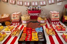 a candy bar is set up on a striped tablecloth with red and white stripes