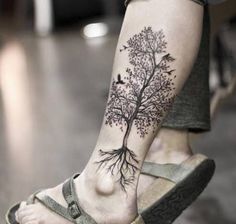 a person with a tree tattoo on their foot and the bottom part of her leg