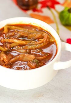 a white bowl filled with soup sitting on top of a table