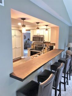 a bar with stools is in the middle of a room