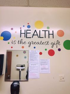 a sign on the wall that says health is the greatest gift with colorful circles around it