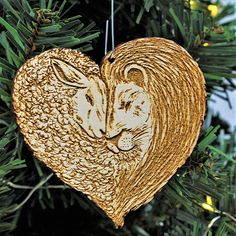 an ornament in the shape of a heart with two cats on it hanging from a tree