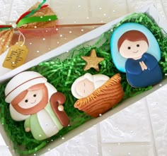 three cookies in a box decorated with nativity figures