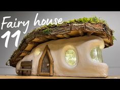 the fairy house is made out of wood and has moss growing on it's roof