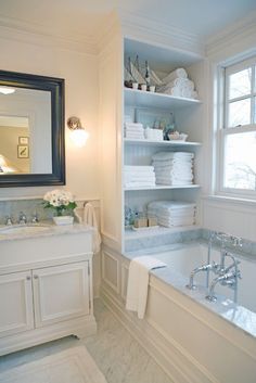 a bath room with a tub a sink and a mirror