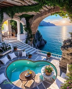 an outdoor swimming pool surrounded by greenery next to the ocean with steps leading up to it