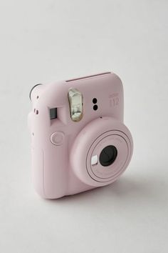 a pink camera sitting on top of a white table