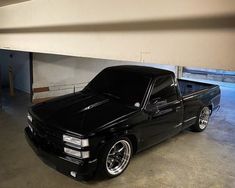 a black pickup truck parked in a garage