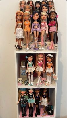 a white shelf filled with lots of dolls on top of it