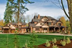 a large house with lots of trees in the front yard and landscaping on the side