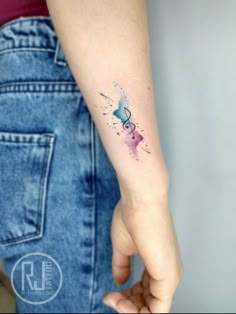 a woman's arm with a small tattoo on it